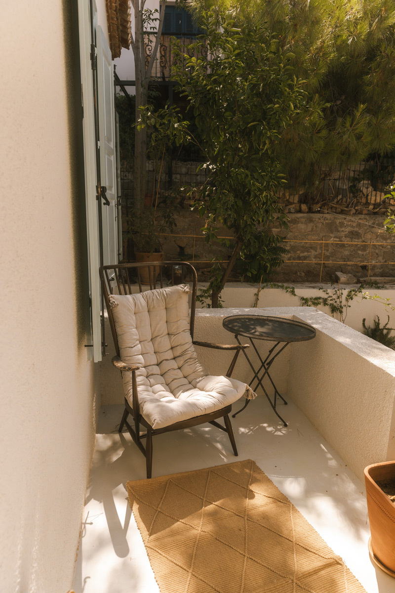 A white chair in a corner on the balkony