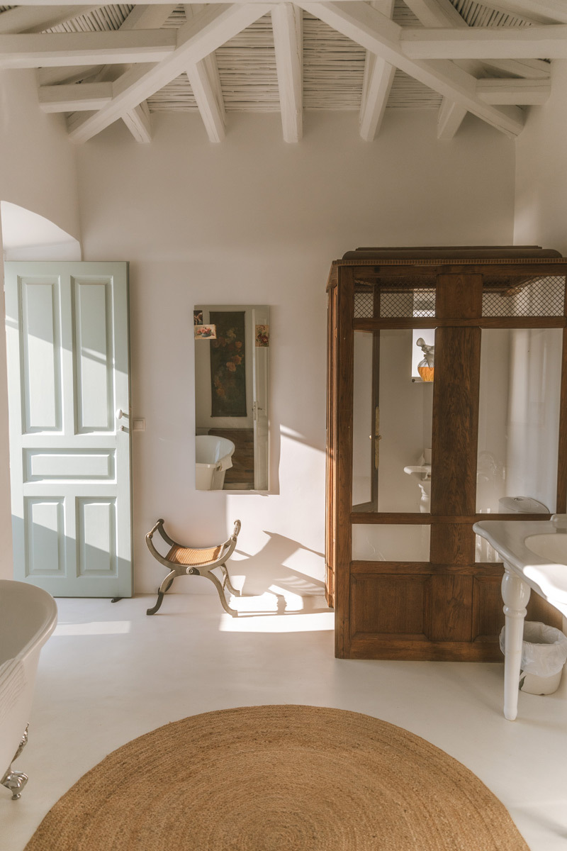 A bathroom with white walls, wooden furniture