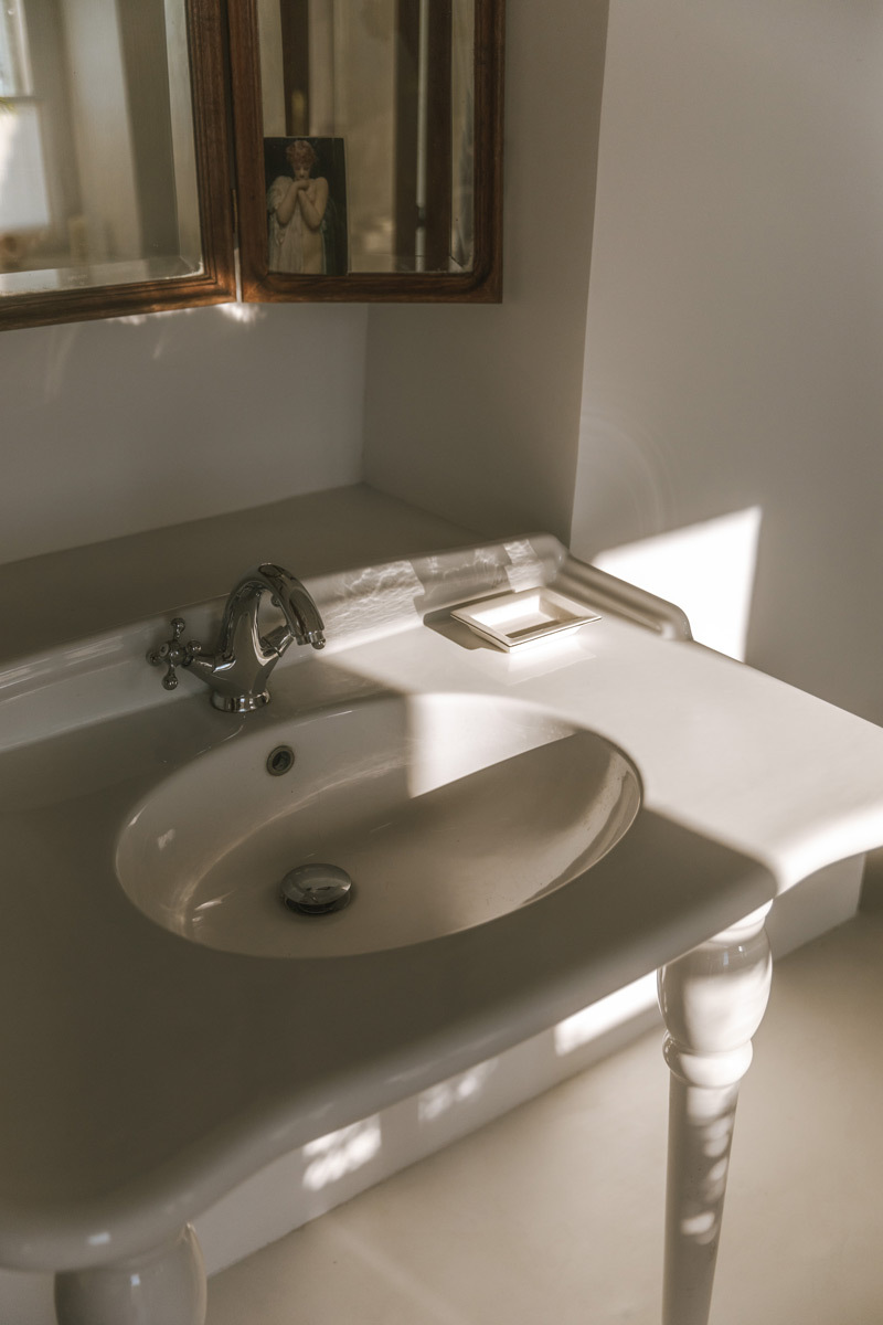 A white sink with a wooden mirror, details