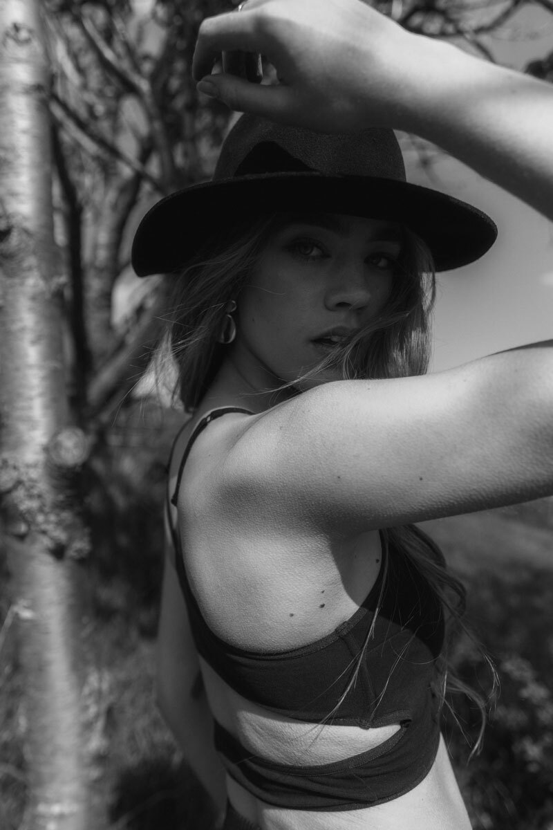 B&W photo of a blonde girl wearing a hat