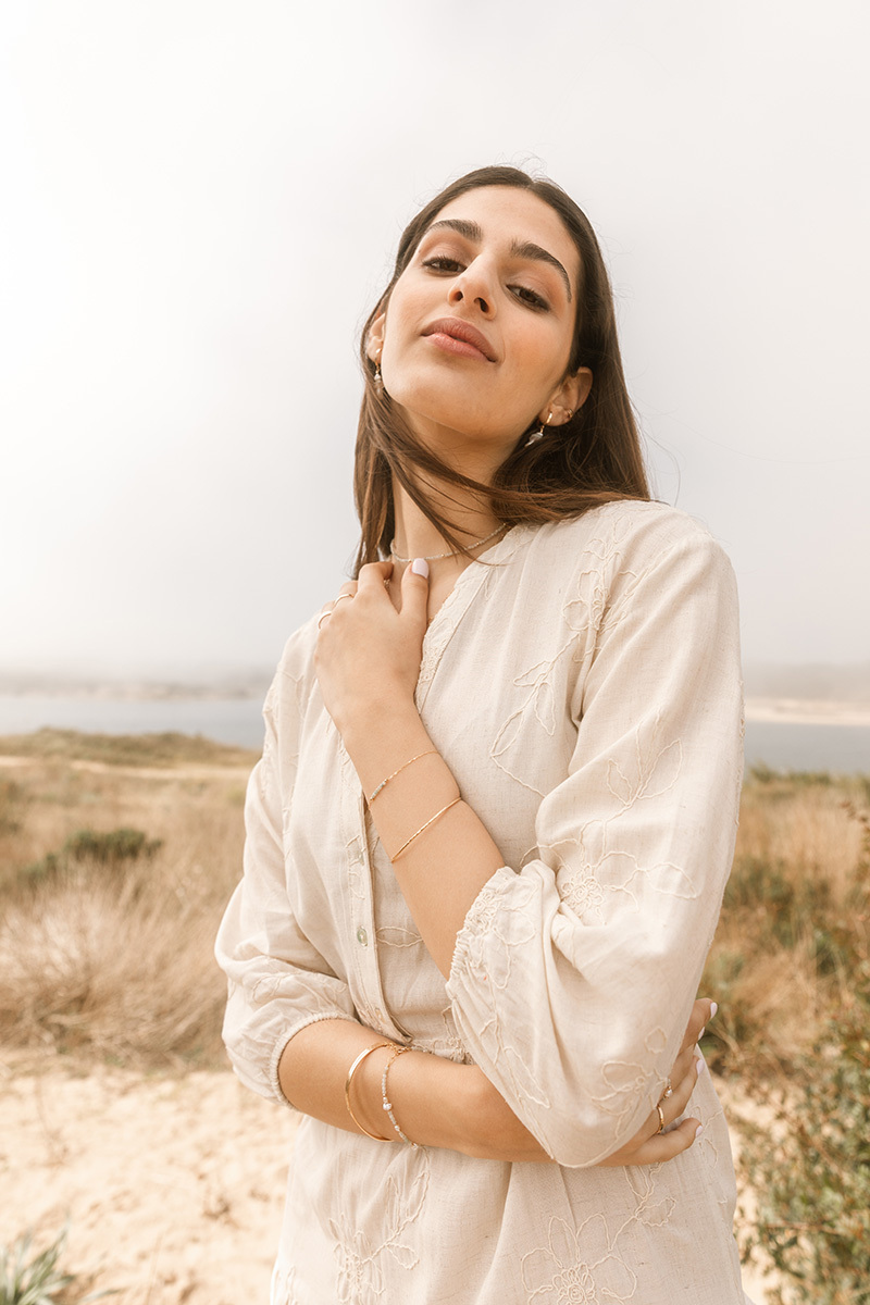 girl on the beach, crossing arms in front of her body