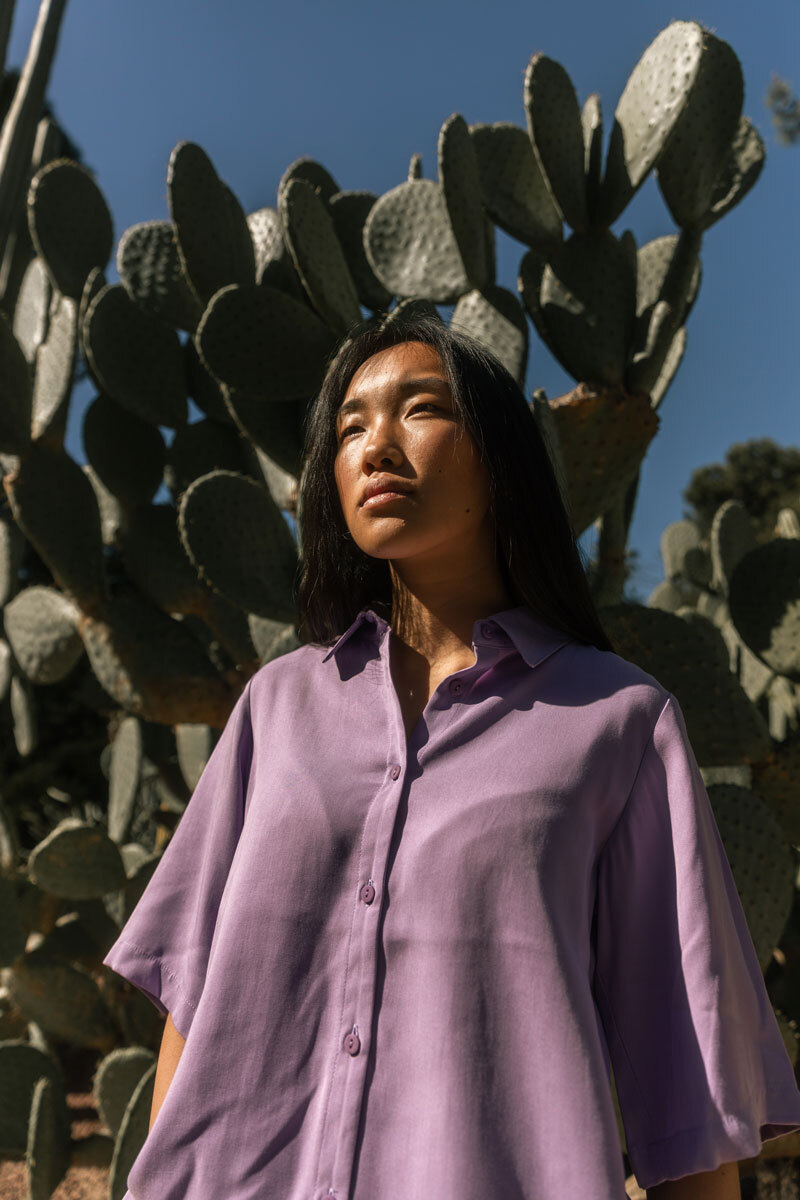 Girl standing in front of a cactus.