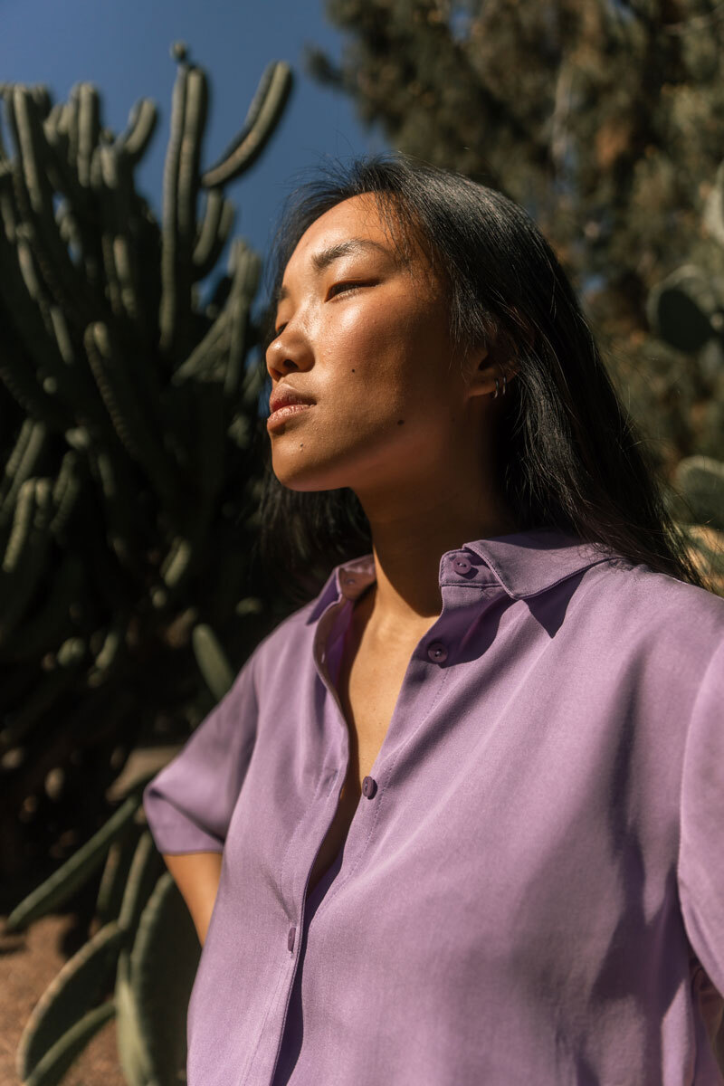 Girl standing in front of a cactus.