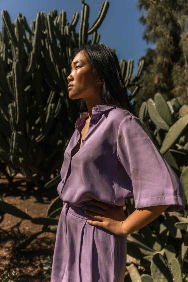 Girl standing in front of a cactus.