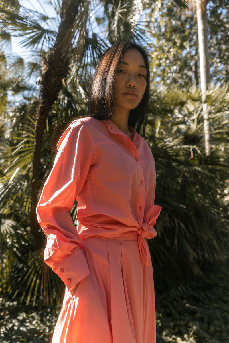 Girl standing in front of a palm tree.