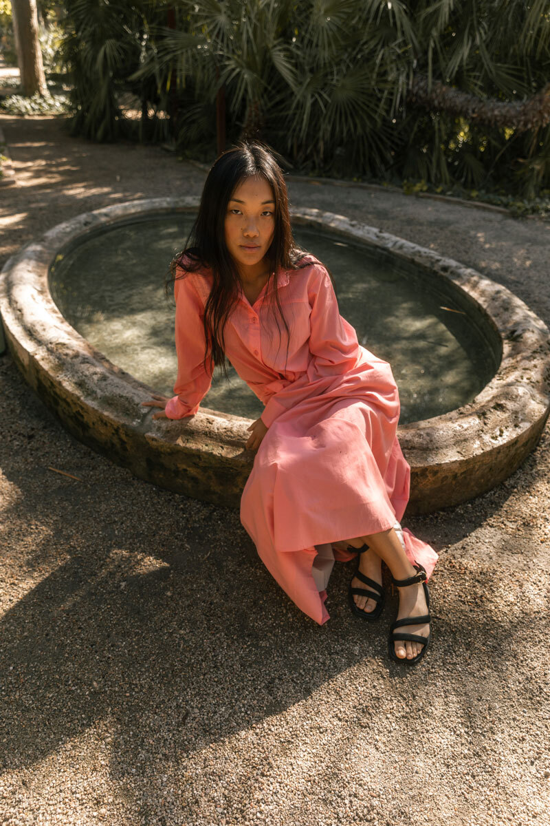 Girl sitting on a fountain.