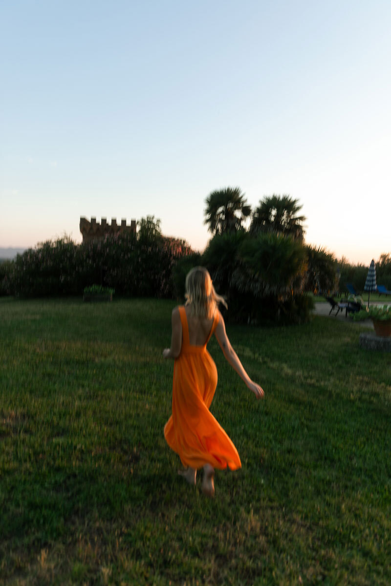 girl in orange dress running over a field