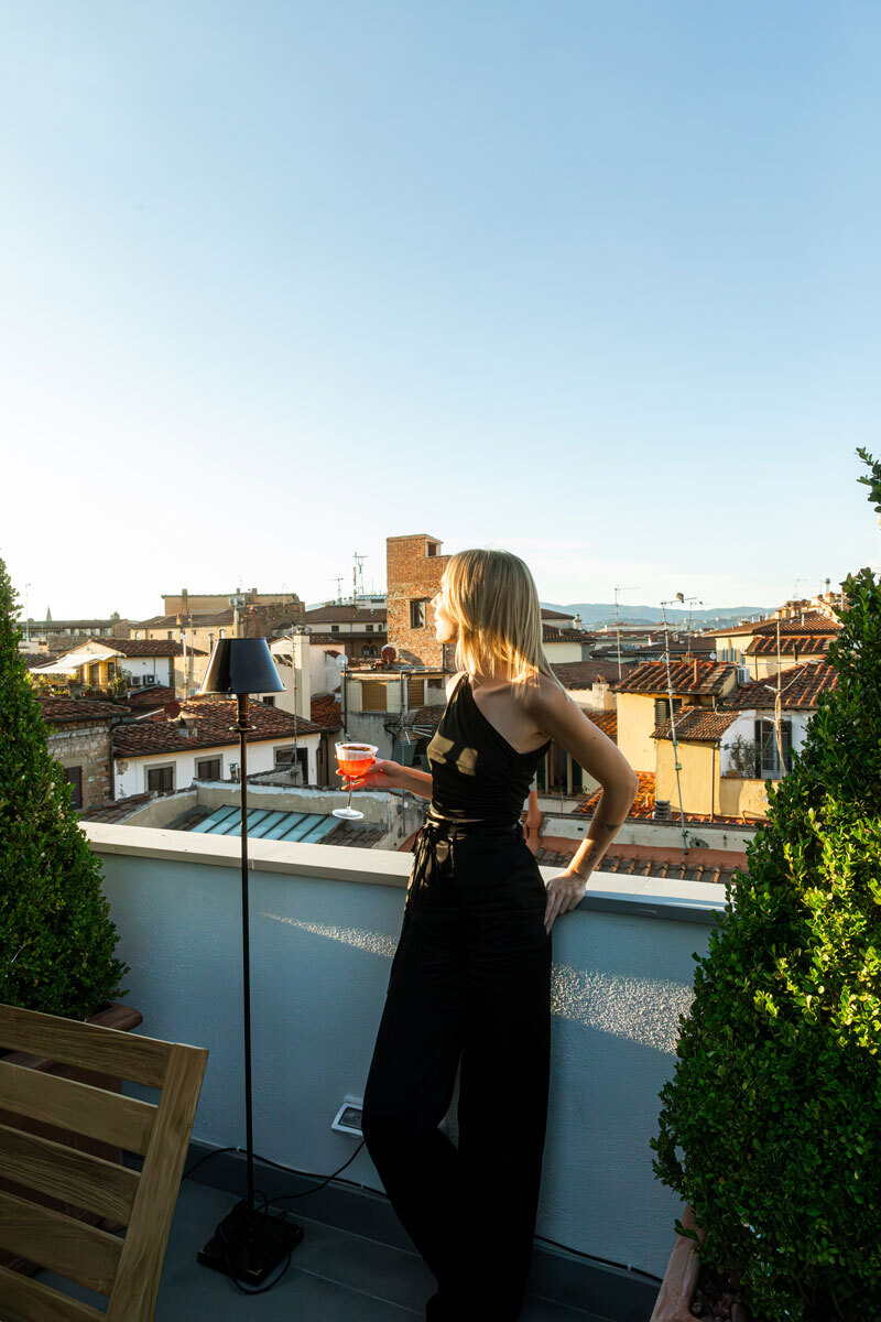 girl standing on a terrace with drink