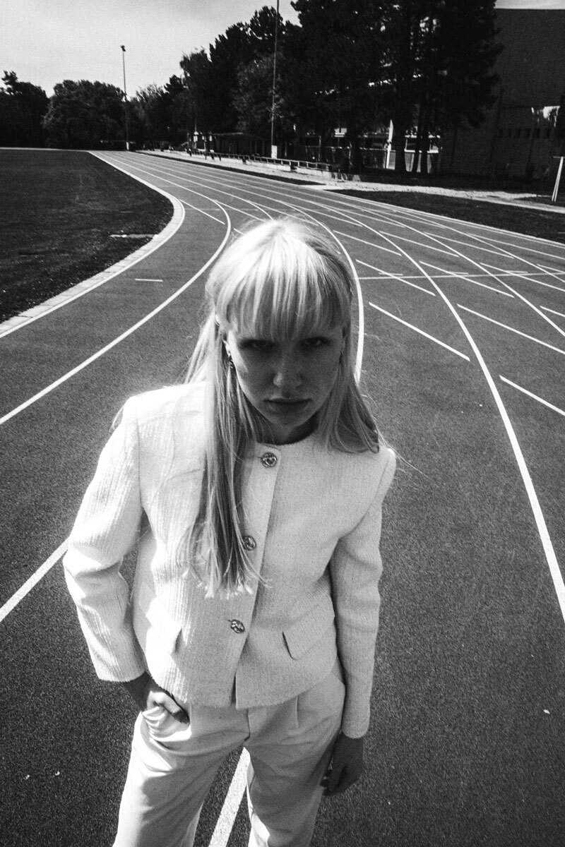 black and white photography of a girl on a running track