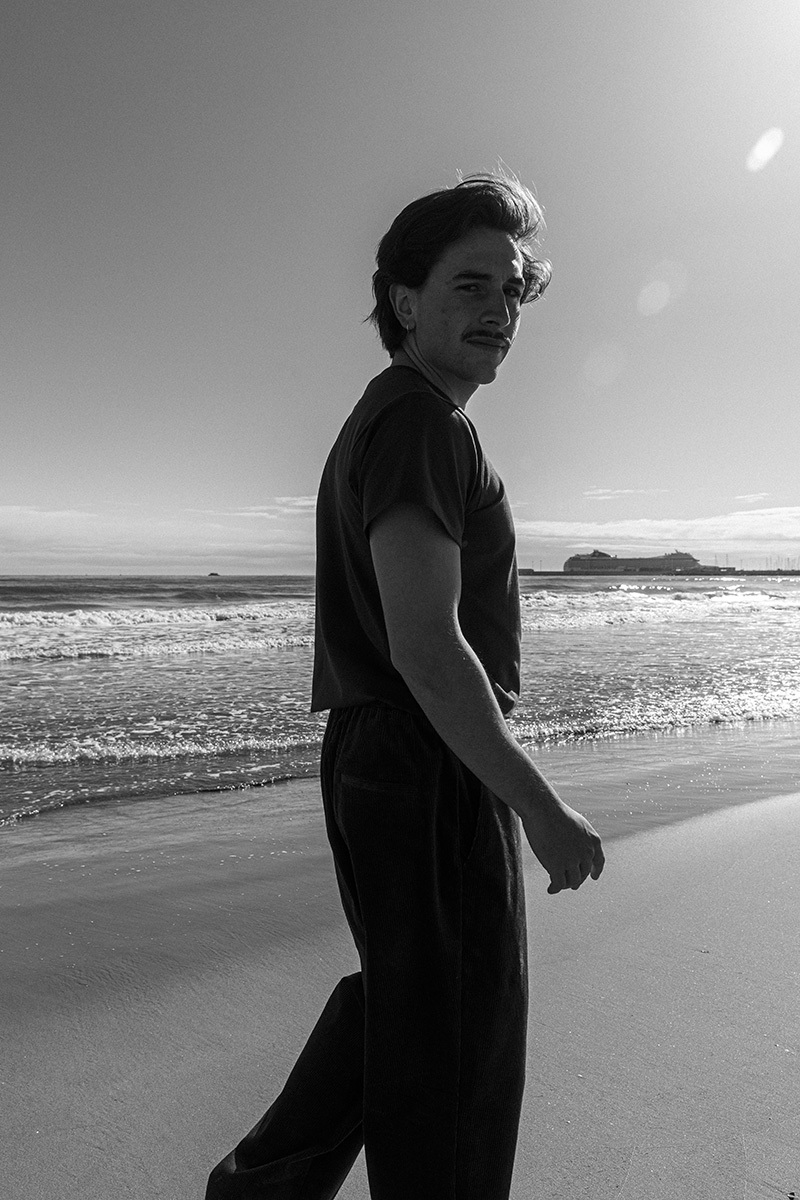 B&W photo of boy in front of the ocean