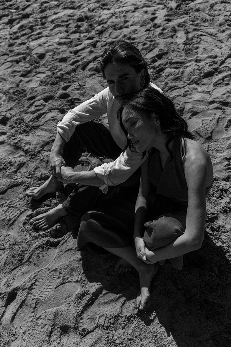 girl and boy sitting in the sand