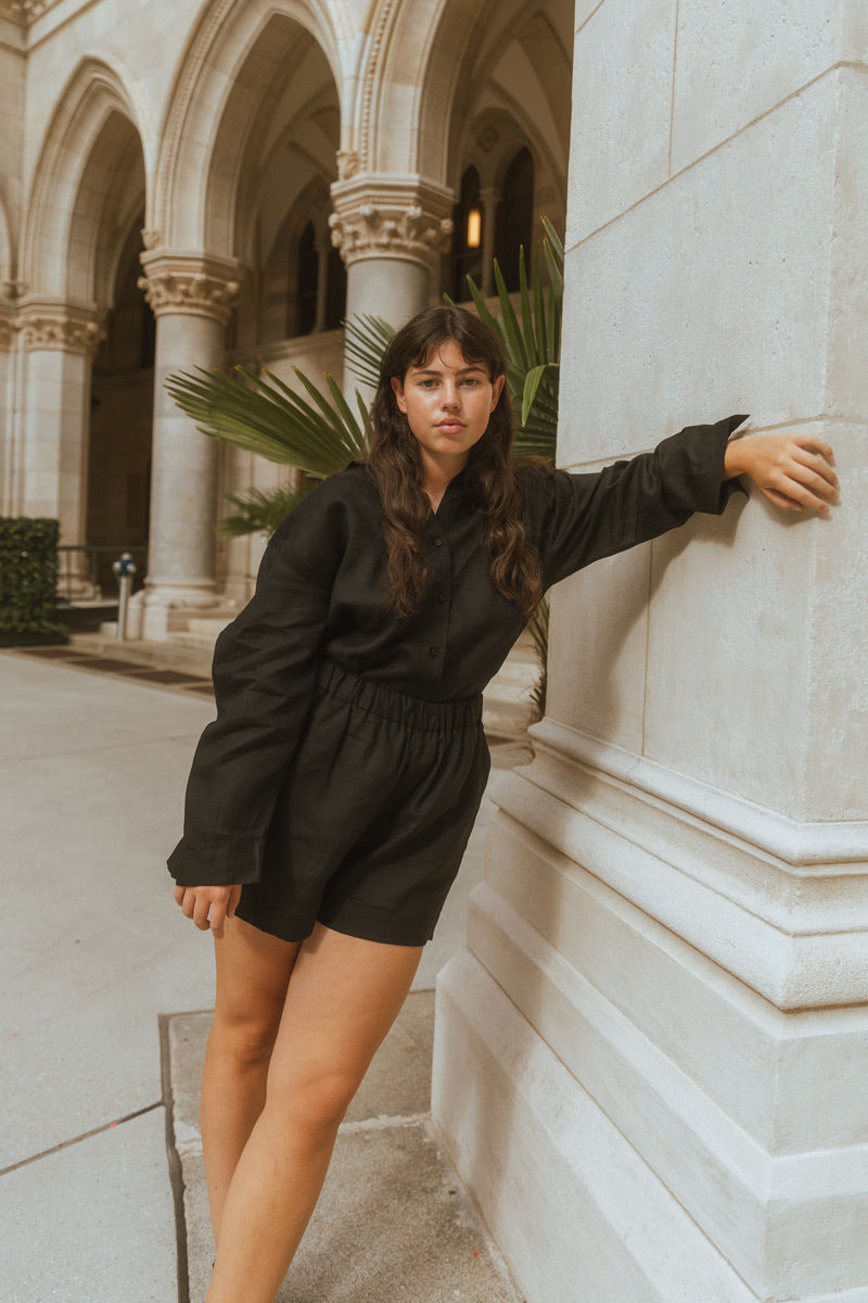 Girl wearing black outfit standing in front of historic building